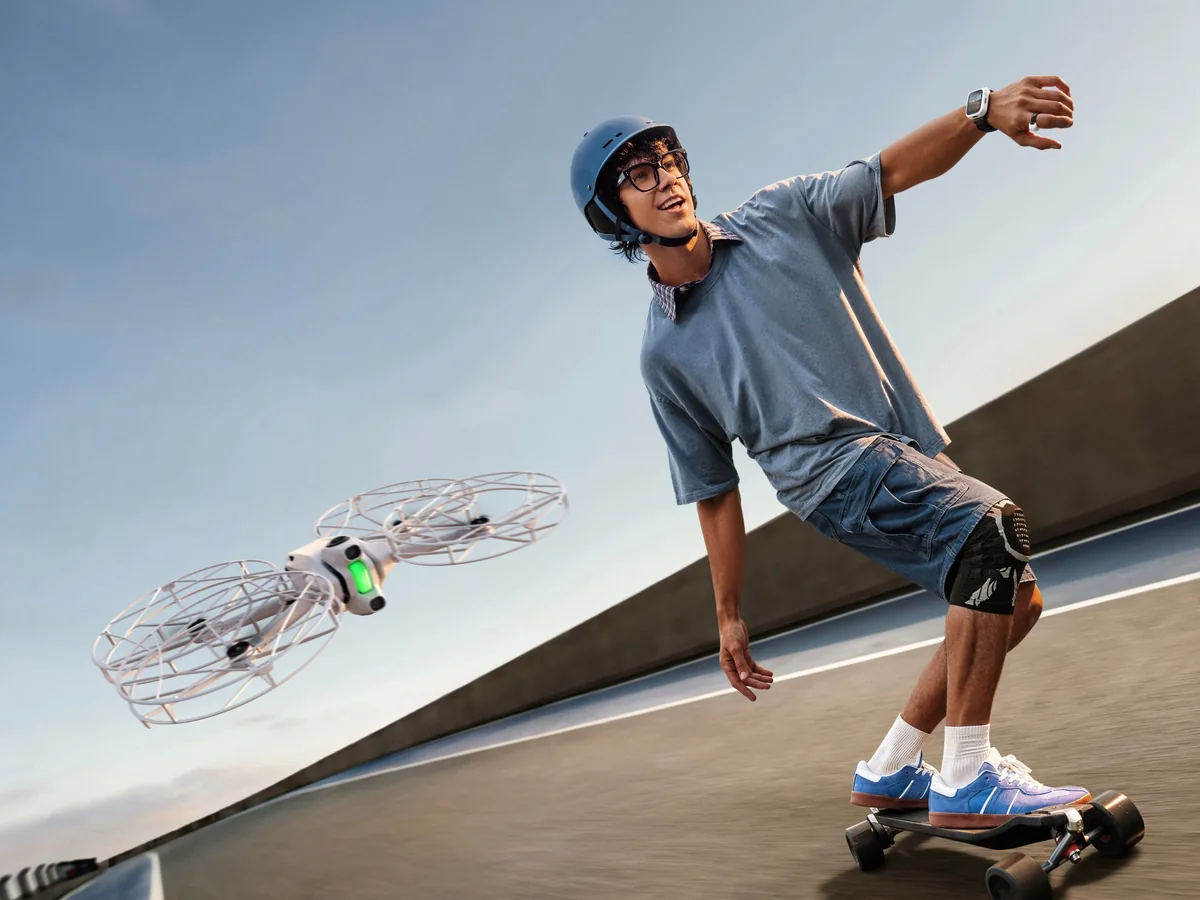 Antigravity A1 s ochrannými krytmi vrtúľ pri jazdcovi na elektrickom skateboarde.