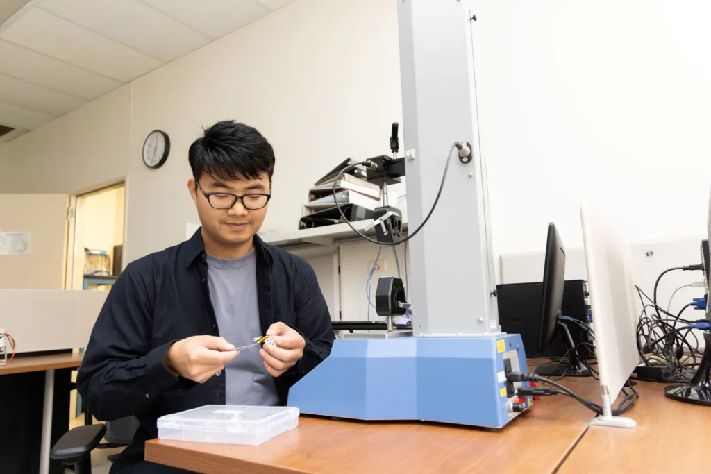 Výskumník Wenzhong Yan pracuje s mikrorobotom v laboratóriu