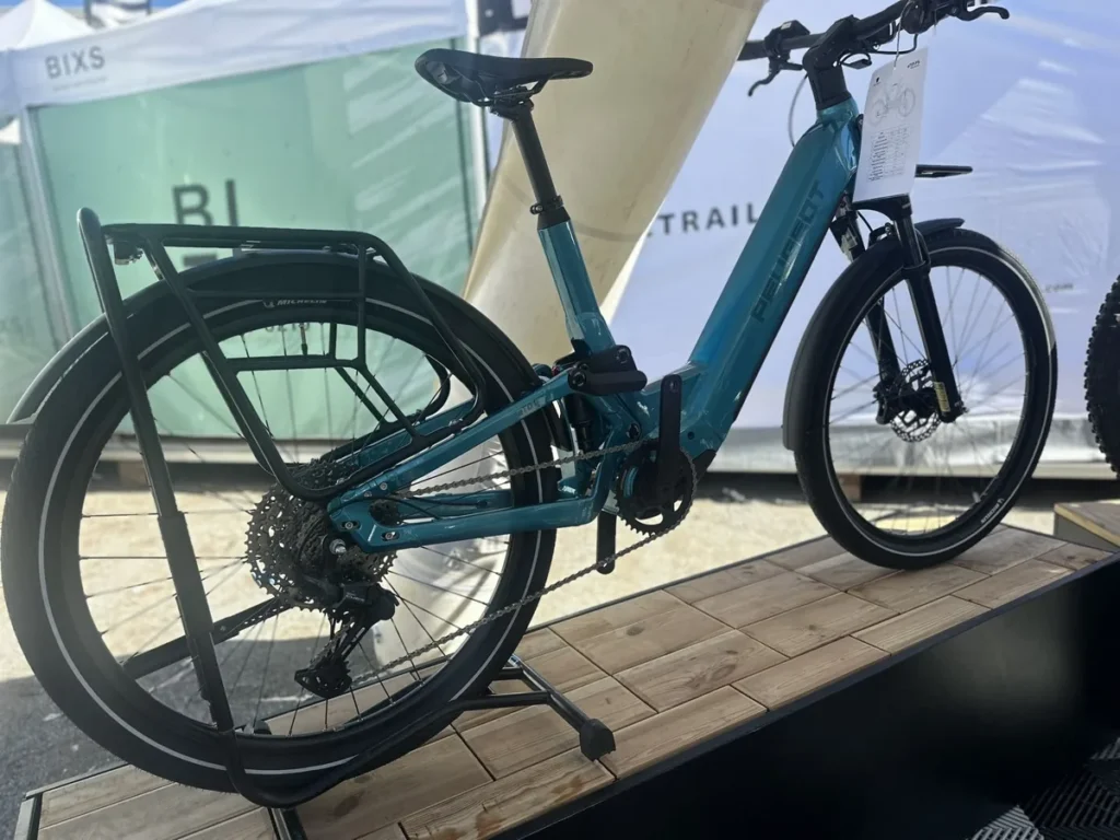 Modrý celoodpružený elektrobicykel Peugeot eT01 FS vystavený na Roc d’Azur