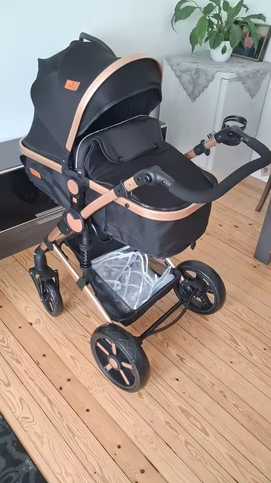 Čierny kočík so zlatým rámom na drevenej podlahe
